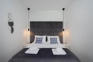 a bedroom with a large bed with two towels on it at Finn Luxury Suites in Split