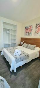sypialnia z dużym łóżkiem z dwoma ręcznikami w obiekcie Pensión San Antón w mieście Sanxenxo