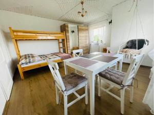 jadalnia ze stołem i krzesłami oraz łóżkiem piętrowym w obiekcie Agroturystyka Pod Dzwonnicą w Zubrzycy Górnej