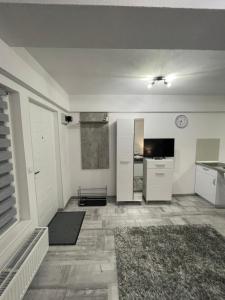 een woonkamer met witte kasten en een keuken bij Jokai Apartments Nr2,code entry in Sfântu-Gheorghe