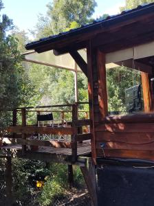 una veranda di una baita di tronchi con finestra di Cabaña en Bosque Nativo a San Carlos de Bariloche