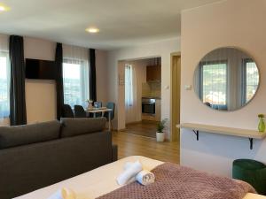 a living room with a couch and a mirror at Guest Rooms Tsarevets in Veliko Tŭrnovo