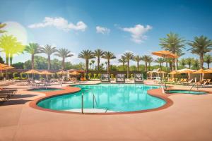ein Pool mit Stühlen und Sonnenschirmen in einem Resort in der Unterkunft Excalibur in Las Vegas