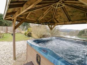 a hot tub under a wooden pergola at Meadowfall at Shatterford Lakes in Bewdley