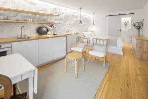 a kitchen and living room with a table and chairs at Casas Rossio by Casas com Estória Boutique Houses in Santa Comba Dão