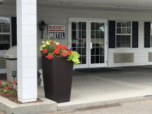 a building with a bucket of flowers in front of it at Budget Motel in Burley