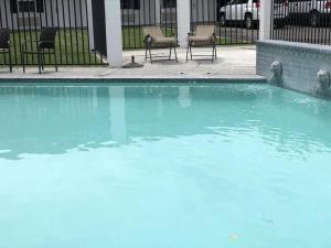 a swimming pool with blue water in front of a building at Budget Motel in Burley