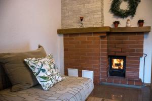 a living room with a brick fireplace and a couch at Rubeņi Jūrmala in Jūrmala