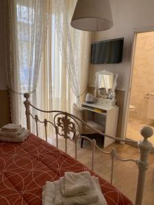 una camera con letto, TV e scrivania di Mahalo a Napoli