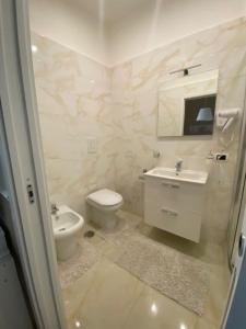 a white bathroom with a toilet and a sink at Mahalo in Naples