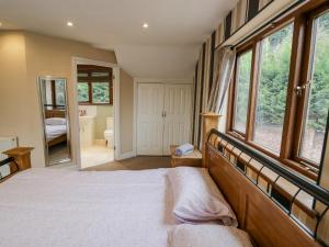 - une chambre avec un grand lit et de grandes fenêtres dans l'établissement Shatterford Lakes, à Bewdley