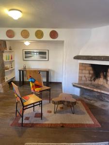 a living room with two chairs and a fireplace at Casa Divinas in Tiradentes