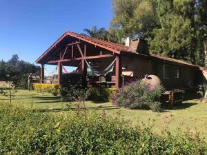 una pequeña casa con un porche en un campo en Playa Tapitos en Tigre