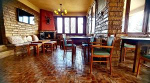 a restaurant with tables and chairs and a brick wall at Hotel Odysseas in Kalyvia