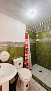 a bathroom with a toilet and a sink and a shower at CASA DE LAS FLORES in Guatemala