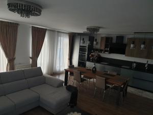 a living room with a couch and a table at Panorama penthouse in Şelimbăr