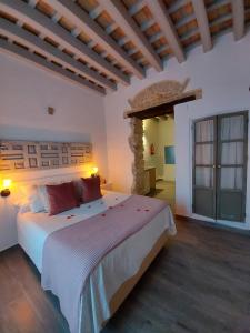 sypialnia z dużym białym łóżkiem w pokoju w obiekcie Alojamientos Plaza de España w mieście Medina Sidonia