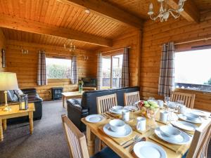 a dining room with a table and chairs and a living room at Valley View in Rhayader