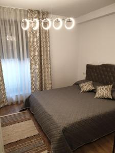 a bedroom with a large bed and a chandelier at Panorama penthouse in Şelimbăr