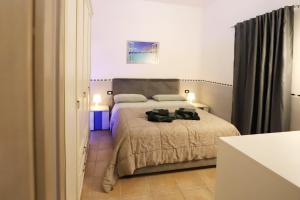 ein Schlafzimmer mit einem Bett mit zwei schwarzen Objekten darauf in der Unterkunft Casa Alma in Neapel