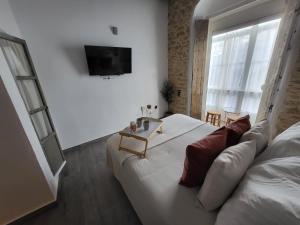 ein Schlafzimmer mit einem weißen Bett und einer Couch in der Unterkunft Alojamientos Plaza de España in Medina-Sidonia