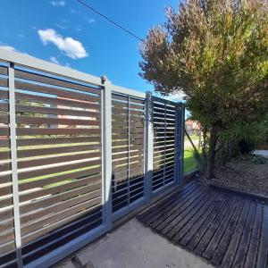 a gate in a fence with a wooden walkway at Increíble casa a 4 cuadras del mar in Mar del Plata
