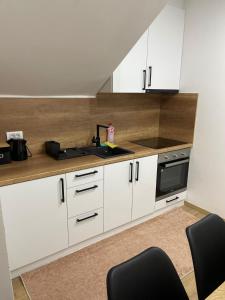 Una cocina con gabinetes blancos y un fregadero. en Apartman Danica 23, en Jahorina