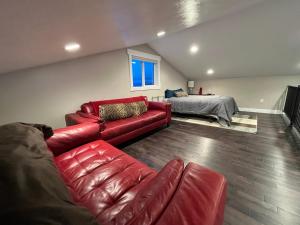 uma sala de estar com um sofá de couro vermelho e uma cama em Home on the green 