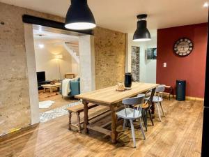 een eetkamer met een houten tafel en stoelen bij La Maison de J. in Chaumont