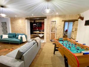 een woonkamer met een grote tafelvoetbaltafel bij La Maison de J. in Chaumont