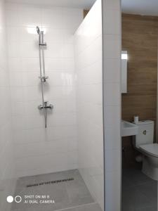 Hostel GREY في موكاشيفو: حمام أبيض مع دش ومرحاض