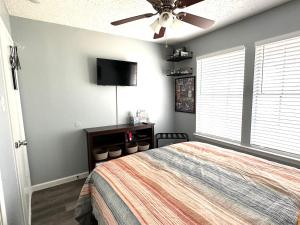 1 dormitorio con 1 cama y ventilador de techo en CASA ATX- Private room and Bathroom in Quiet Neighborhood, en Austin
