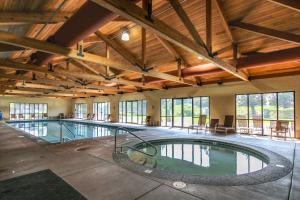 a large indoor swimming pool in a building with windows at Creekside Village in Redmond