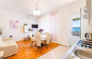 - une cuisine et une salle à manger avec une table et des chaises dans l'établissement Apartments Tatjana Crikvenica, à Crikvenica