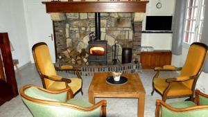 a living room with a fireplace and a table and chairs at Le Pressoir in Beaumesnil