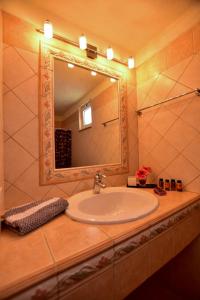 een badkamer met een wastafel en een spiegel bij Villa Koomas - kakodiki Paleochora in Avdhoulianá