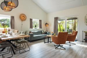 uma sala de estar com uma mesa e um sofá em Nesserduinen em Nes