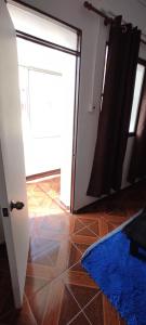 Habitación con puerta abierta y alfombra azul en Departamento monoambiente centrico en Arica