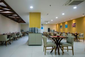 馬塞約的住宿－Verano Pajuçara by Tropicalis，用餐室设有桌椅和黄色的墙壁