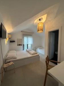 a white bedroom with a large bed and a window at Villa Vele in Herceg-Novi