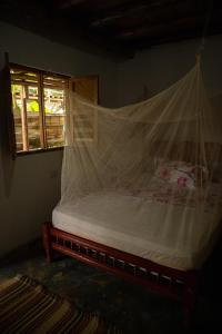Bett mit Moskitonetz in einem Zimmer in der Unterkunft Cabaña Buenos Aires in Palomino