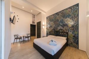 1 dormitorio con 1 cama con tapiz grande en la pared en B&B Al Vico en Trani