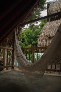 a hammock hanging from a building with trees in the background at Cabaña Buenos Aires in Palomino