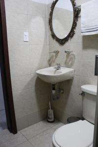 y baño con lavabo, aseo y espejo. en Hospedaje maderos, en Armenia