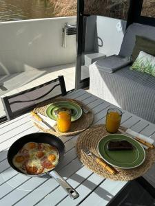 a table with two plates of food and drinks on a boat at Casa barco Valada in Morgado