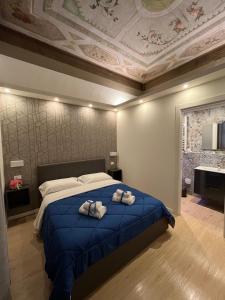 1 dormitorio con 1 cama con 2 toallas en La Suite Deluxe Rooms & Apartments en Bolonia