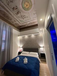a bedroom with a blue bed with a ceiling at La Suite Deluxe Rooms & Apartments in Bologna