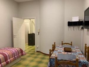een kamer met een tafel, een bed en een deur bij Vesuvio House in Boscoreale
