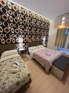 a bedroom with two beds and a wall of wine bottles at La Suite Deluxe Rooms & Apartments in Bologna