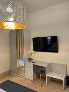 a room with a desk and a television on a wall at La Suite Deluxe Rooms & Apartments in Bologna
